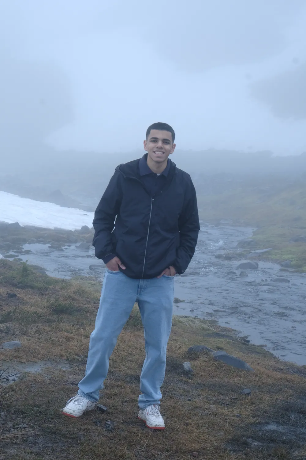 Youhanna Dimian standing on a misty riverbank at Mount Rainier
